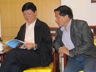 江苏省教育厅副厅长（左）胡金波听取王錞校长工作汇报